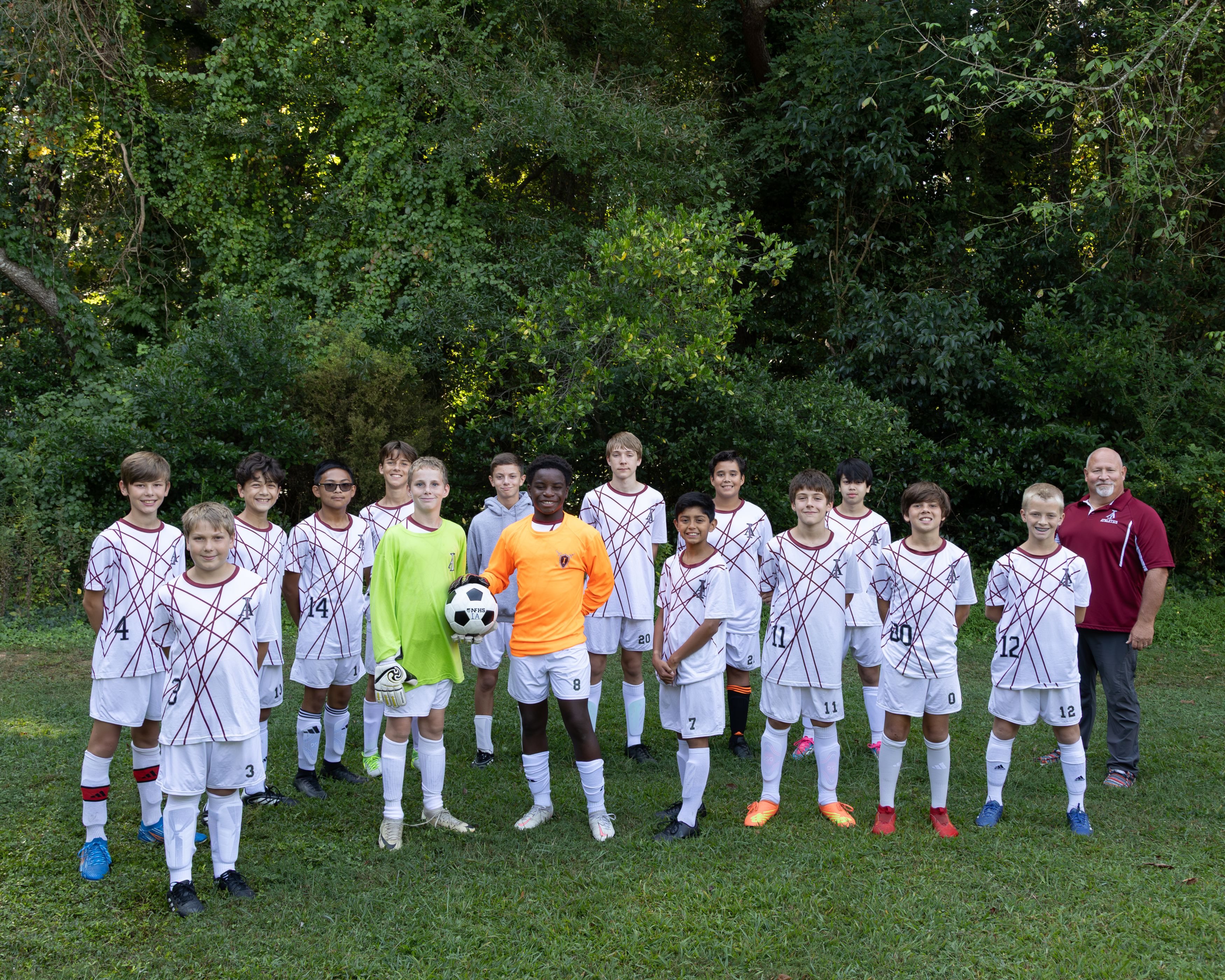 Image shows 15 members of the middle school soccer team and their coach.